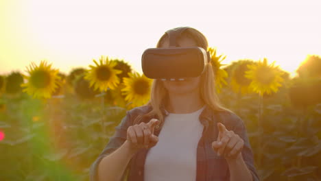 Female-modern-farmer-in-a-field-with-sunflowers-uses-VR-technology.-Simulating-the-application's-user-interface.-Control-the-irrigation-system-with-drones.-Inspect-the-field-using-drones.